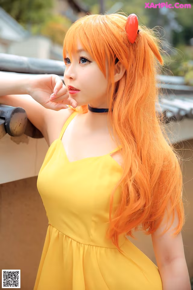 A woman in a yellow dress posing for a picture.