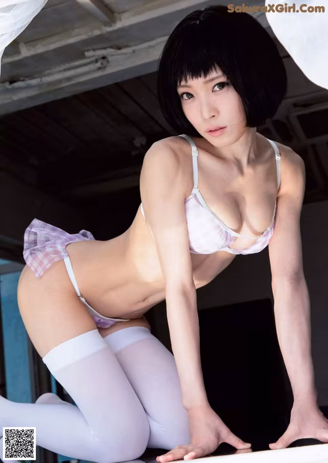 A woman in a white lingerie and stockings posing for a picture.