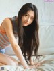 A woman sitting on top of a white couch.