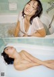 A woman laying in a bathtub with water on her body.