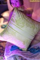 A woman sitting on a bed holding a pillow.