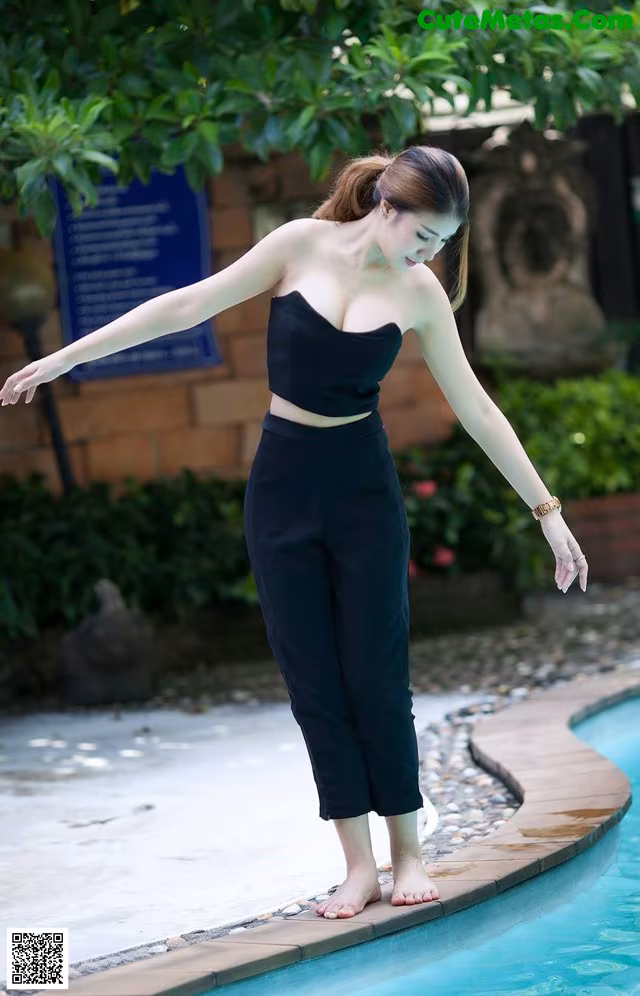 A woman standing on the edge of a swimming pool.