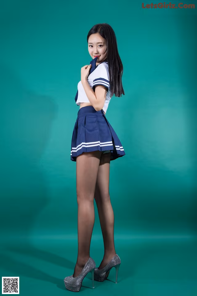 A woman in a school uniform posing for a picture.