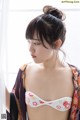 A woman in a kimono looking out a window.